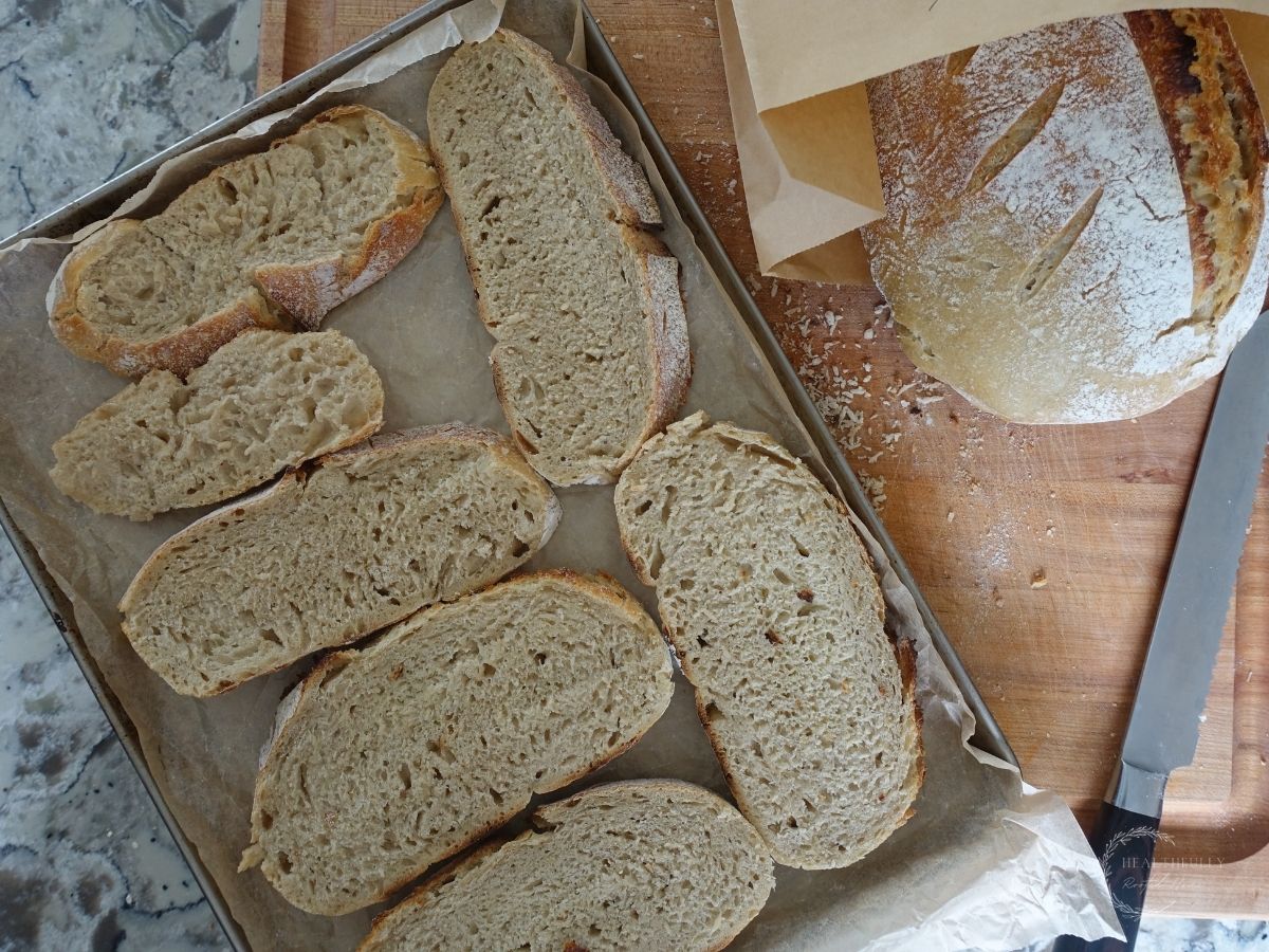 sliced sourdough bread on a baking tray about to go into the freezer for storage