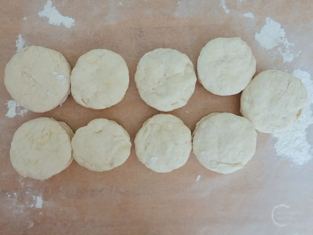 shaped lemonade scones made without cream on a parchment lined baking sheet ready for baking.