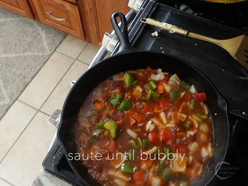 sauteing vegetales in sweet and sour sauce in a cast iron skillet