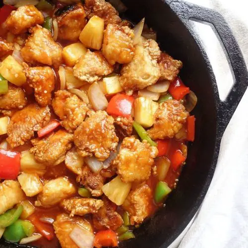 hong kong style sweet and sour chicken in a cast iron skillet