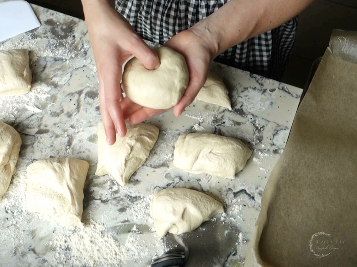 using thumb to poke a hole in sourdough discard bagel dough