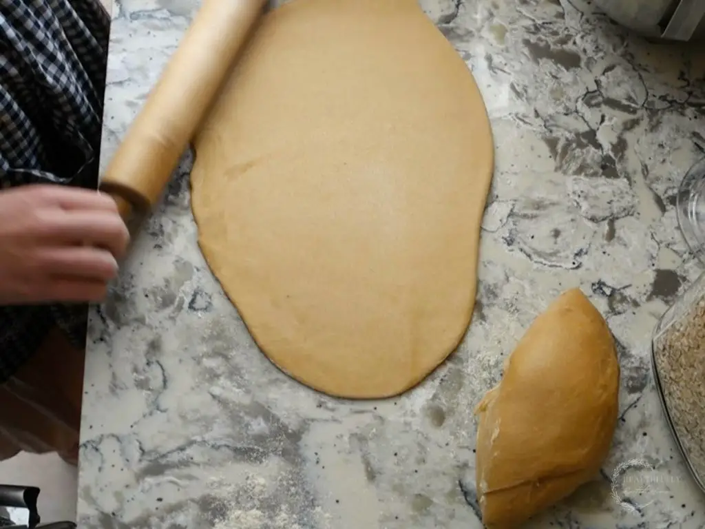 rolling out the sourdough babka dough into a rectangle using a rolling pin