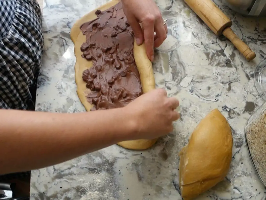 rolling the sourdough babka dough tightly into a log
