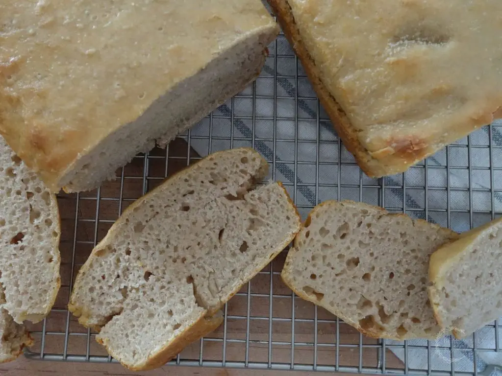 sourdough sandwich bread loaves with slices all around it