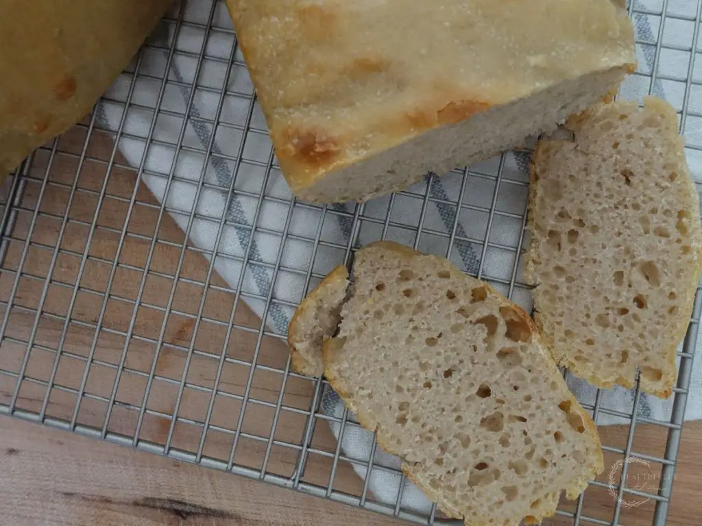 close up of the crumb on slices of fermented sandwich bread as it cools on wire cooling racks