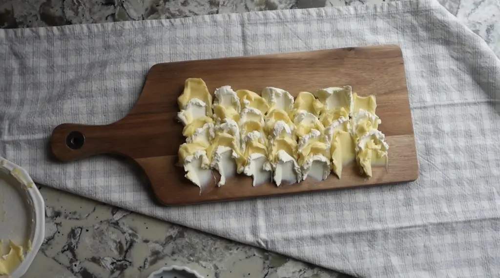 dolloped butter and cream cheese on a serving platter to make a butter board