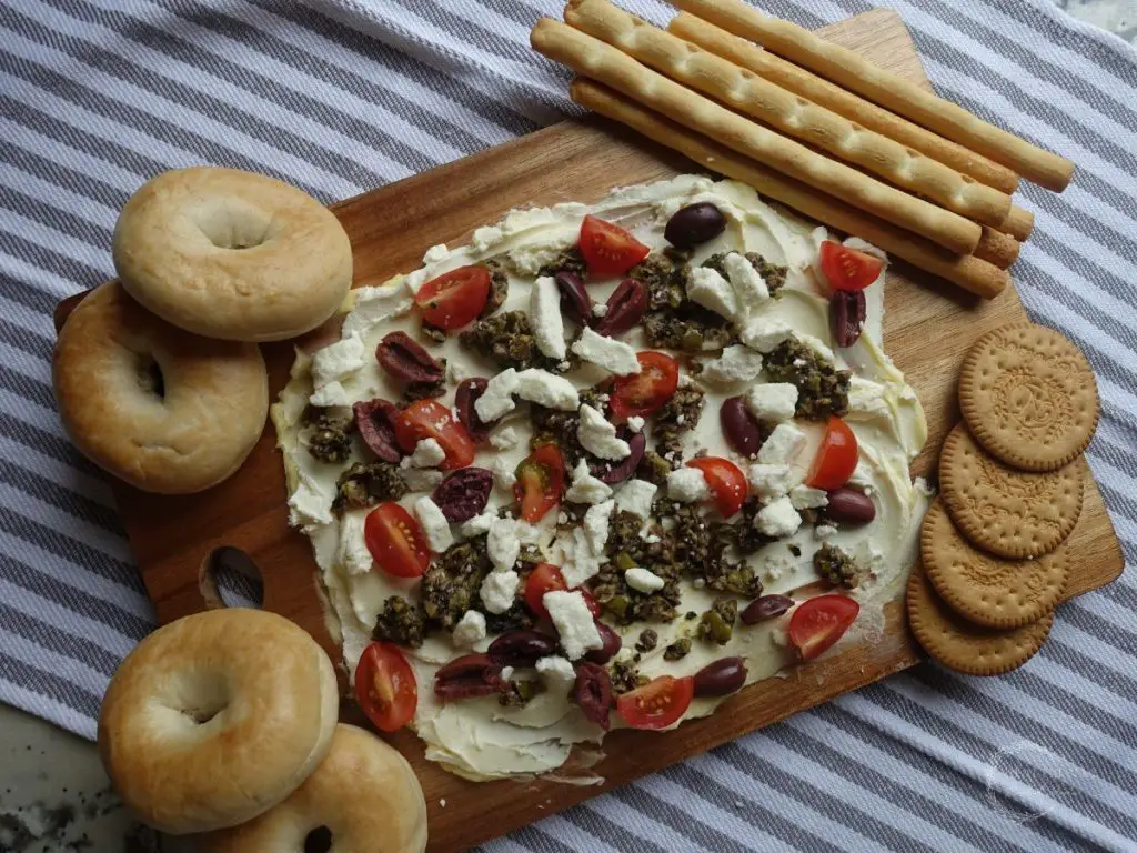 greek style butter board with crackers and bagels
