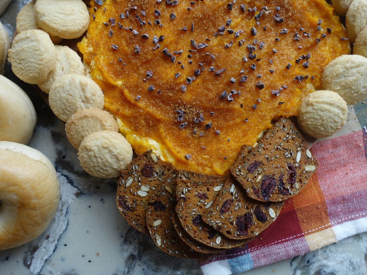 pumpkin butter board with crackers and cookies on the side