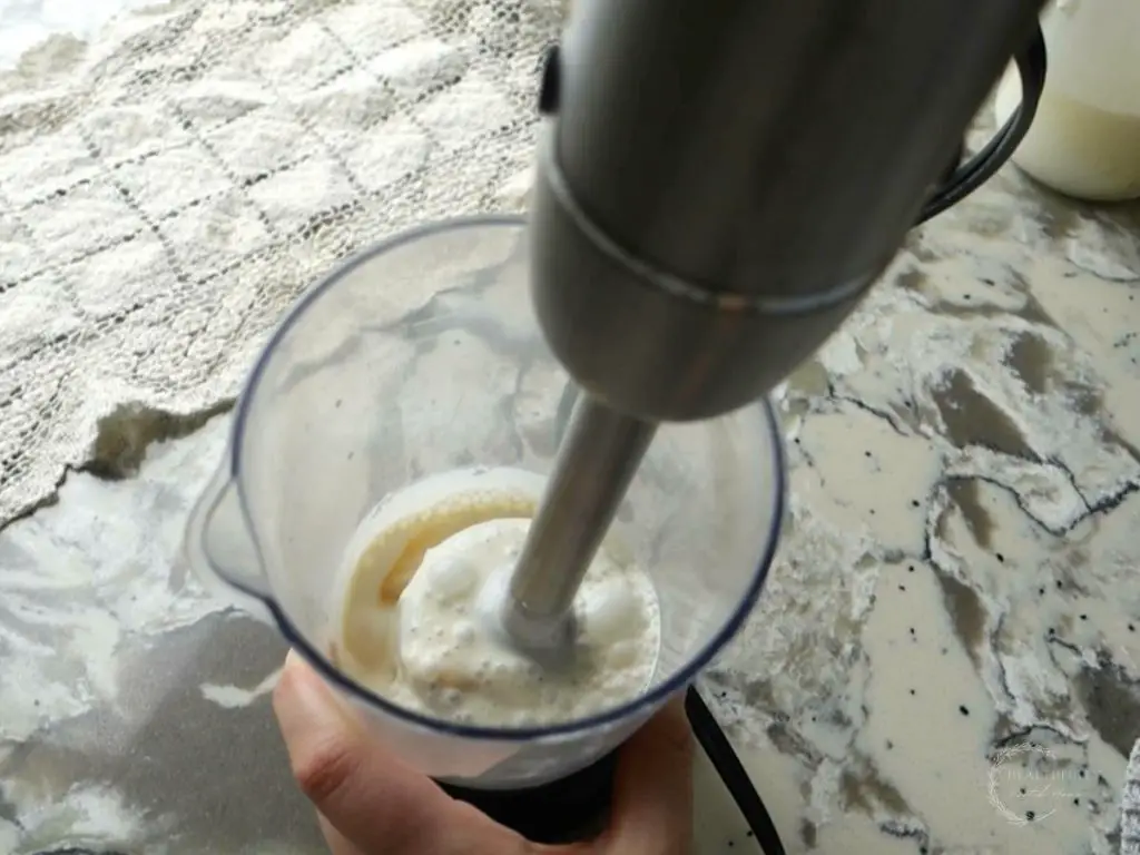 blending ingredients for salted caramel cold foam with an immersion blender 