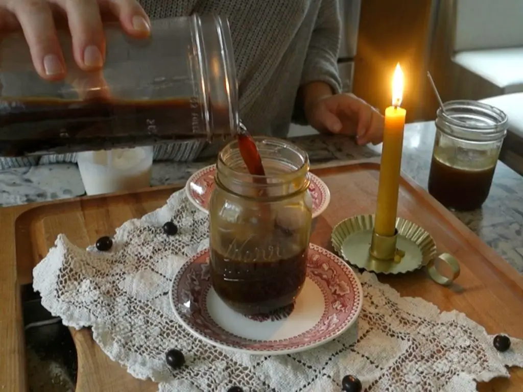 cold brew coffee being poured into a mason jar