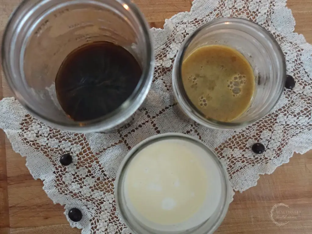 ingredients to make salted caramel cold foam on a lace doily with espresso beans surrounding
