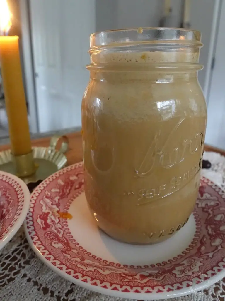 easy salted caramel cold foam cold brew with a candle in the background and red plates underneath 