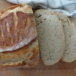 Sourdough discard bread artisan loaf sliced next to a tea towel