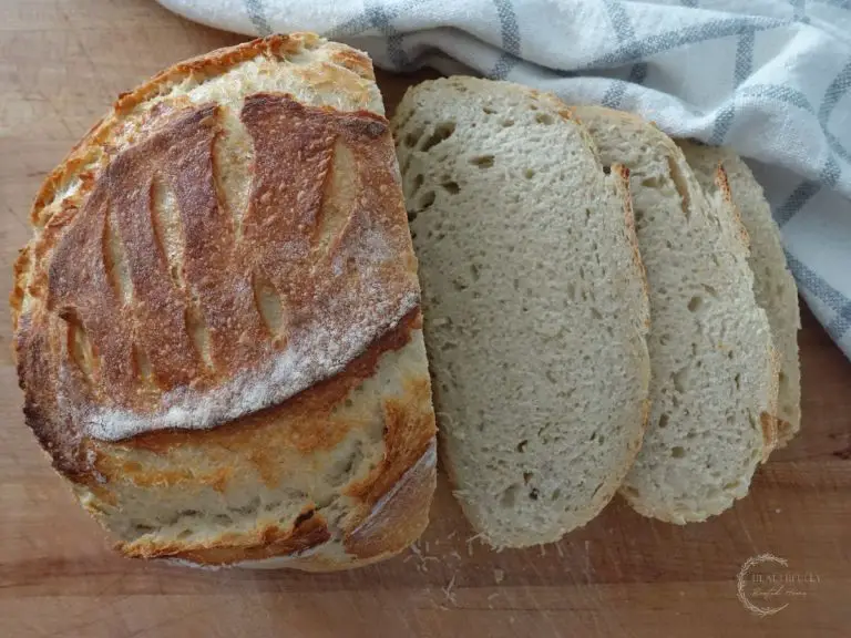 Sourdough discard bread artisan loaf sliced next to a tea towel