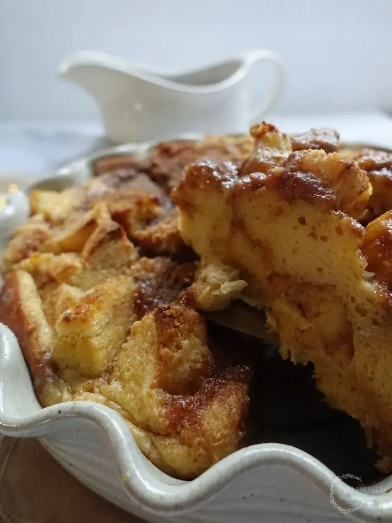 brioche french toast casserole with a slice being lifted out of the dish so you can see the inside of the casserole