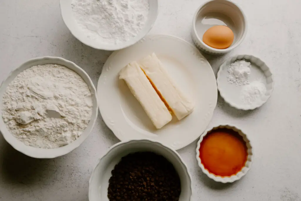 ingredients to make chocolate chip sugar cookies in white bowls