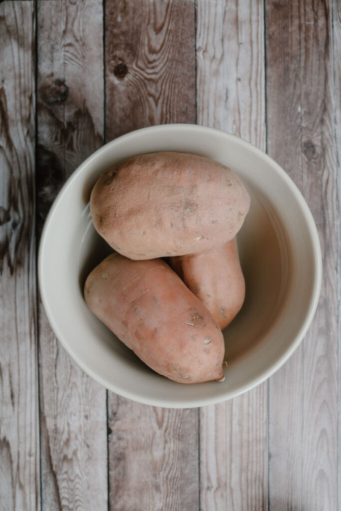 bowl of sweet potatoes with wooden background shown as an alternative to applesauce